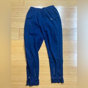 Blue Nike sweats. Zip up and down.